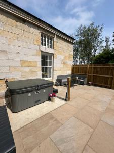 a patio with a hot tub next to a building at Farrier's Rest in Belford