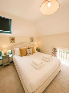 a bedroom with a large white bed with a flat screen tv at Farrier's Rest in Belford