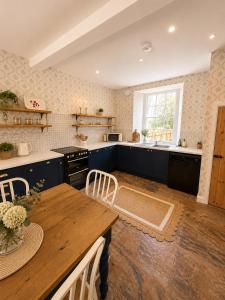 a kitchen with blue cabinets and a wooden table at Farrier's Rest in Belford