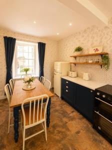 a kitchen with a wooden table and a refrigerator at Farrier's Rest in Belford +10 photos