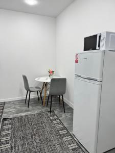 a kitchen with a refrigerator and a table with chairs at APARTMENT Ultra central in Edineţ