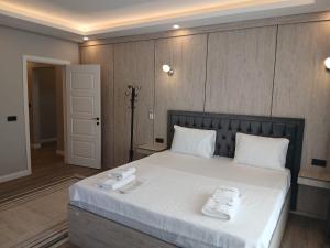a bedroom with a large bed with two towels on it at Sunset Hill Hotel in Büyükçekmece