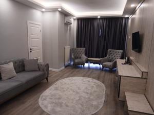 a living room with a couch and chairs and a table at Sunset Hill Hotel in Büyükçekmece