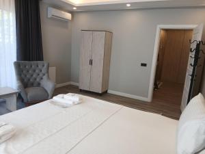 a bedroom with a bed and a chair and a door at Sunset Hill Hotel in Büyükçekmece