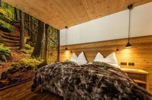 a bedroom with a large bed in the woods at HOTEL B&B MARILENA in Arabba