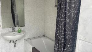 a bathroom with a sink and a shower curtain at City-Wohnung Oldenburg-Pferdemarkt in Oldenburg