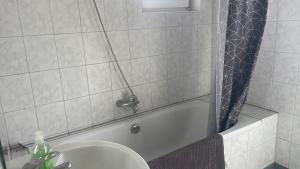 a bathroom with a tub and a sink and a shower at City-Wohnung Oldenburg-Pferdemarkt in Oldenburg