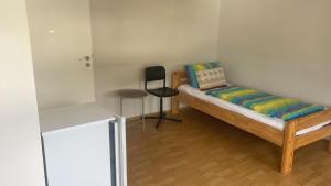 a small room with a bed and a chair at City-Wohnung Oldenburg-Pferdemarkt in Oldenburg