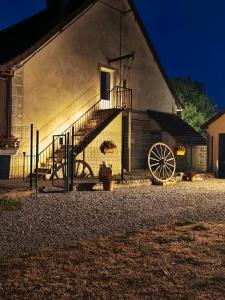 a building with a staircase and a wheel next to it at Chambre d'hôte in Maligny
