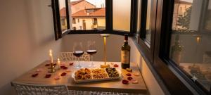 a table with a bottle of wine and wine glasses at Vittoria Mini Apartment in Campobasso