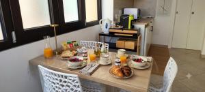 a table with breakfast foods and orange juice on it at Vittoria Mini Apartment in Campobasso +31 photos