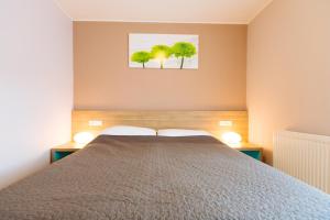 a bedroom with a bed and two trees on the wall at Maline Apartments in Bled