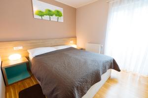 Un dormitorio con una cama grande y una ventana en Maline Apartments, en Bled