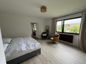 a bedroom with a bed and a large window at Gemütliche Ferienwohnung direkt am Waldrand in Dörentrup