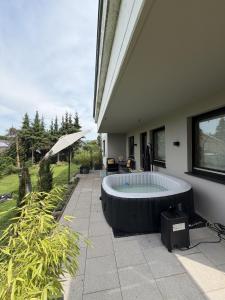 a hot tub sitting on a patio next to a house at Gemütliche Ferienwohnung direkt am Waldrand in Dörentrup +27 photos