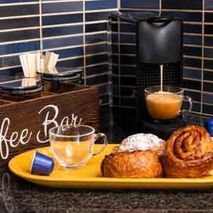 a plate of food with coffee and pastries on a counter at שורשי הגליל - 6 בקתות מדהימות עם ג'קוזי, גינה וקרבה לנחלים in Yuval