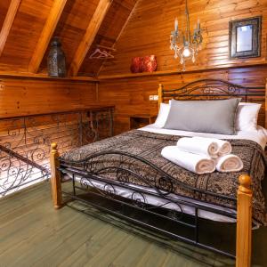 a bedroom with a bed with towels on it at שורשי הגליל - 6 בקתות מדהימות עם ג'קוזי, גינה וקרבה לנחלים in Yuval