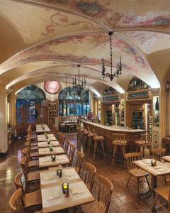 a restaurant with tables and chairs and a bar at Hotel Excelsior Munich in Munich