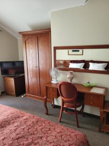 a bedroom with a desk and a chair and a bed at Vila Florena Garden in Palanga