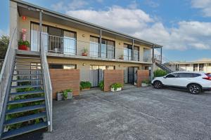 a building with a car parked in a parking lot at Apollo Bay Waterfront Motor Inn in Apollo Bay