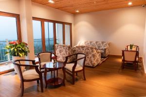 a living room with a table and chairs and a couch at Memories Hotel in Bảo Lộc