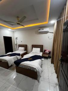a bedroom with two beds and a ceiling at Abu Khalid By MZ Hotels & Restaurant in Mingāora +14 photos