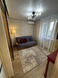 a living room with a blue couch and a window at Elegant Apartment City Center in Tiraspol