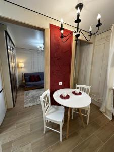 a dining room with a white table and chairs at Elegant Apartment City Center in Tiraspol