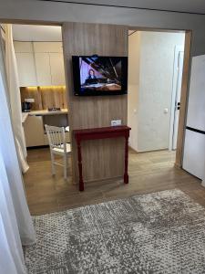 a living room with a table and a tv on a wall at Elegant Apartment City Center in Tiraspol