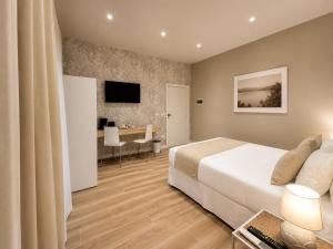 a bedroom with a bed and a desk and a television at Harmony House Prestige in Pisa