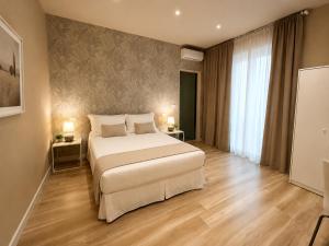 a bedroom with a large white bed in a room at Harmony House Prestige in Pisa
