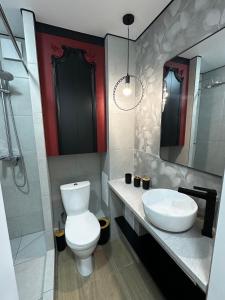 a bathroom with a white toilet and a sink at Elegant Apartment City Center in Tiraspol +8 photos