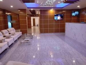 a lobby with couches and a tv in a building at Dhaka Residence Hotel in Dhaka