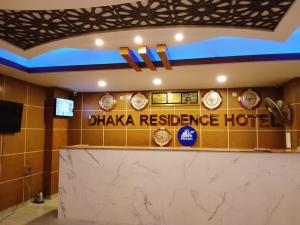 a hotel lobby with clocks on the wall at Dhaka Residence Hotel in Dhaka