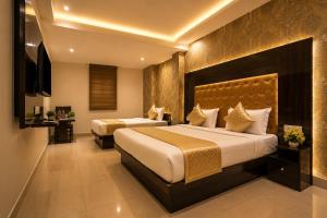 a hotel room with two beds and a television at HOTEL ICONIC At Delhi International Airport in New Delhi