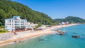 an aerial view of a beach with a building at Youngduk Sea & Spa Pension in Yŏngdŏk