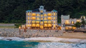 a large building on the beach with the water at Youngduk Sea & Spa Pension in Yŏngdŏk