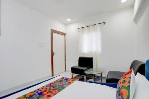 a bedroom with a bed and a chair and a table at FabHotel MV Luxury Rooms in Hyderabad +34 photos