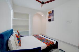 a small bedroom with a bed and a blue couch at FabHotel MV Luxury Rooms in Hyderabad