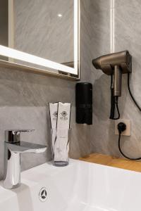 a bathroom sink with a blow dryer on the counter at Auris Hotel & Restobar in Almaty +59 photos