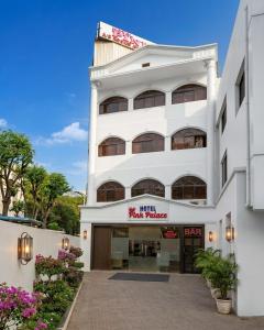 a white building with a sign on the front of it at Hotel Pink Palace - Triplicane, Chennai in Chennai