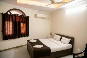 a bedroom with a bed and a window with towels at Hotel Pink Palace - Triplicane, Chennai in Chennai
