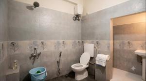 a bathroom with a toilet and a sink at Hotel Pink Palace - Triplicane, Chennai in Chennai