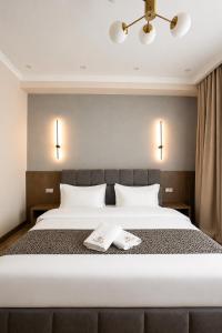 a bedroom with a large bed with two towels on it at Auris Hotel & Restobar in Almaty