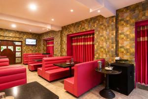 a red restaurant with red chairs and tables at Hotel Pink Palace - Triplicane, Chennai in Chennai +20 photos
