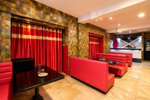 a restaurant with red chairs and a red curtain at Hotel Pink Palace - Triplicane, Chennai in Chennai