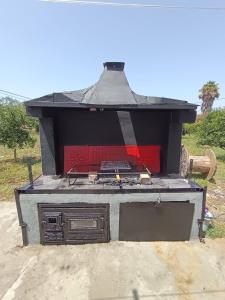 ein Außengrill mit roter Tür und Elementen in der Unterkunft PANKO Suite in Dhímitra