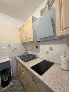 a kitchen with wooden cabinets and a stove top at Studio app Ana in Kostrena