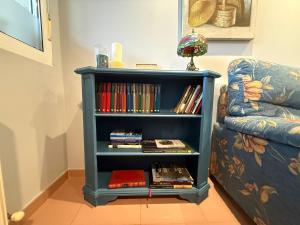 Neben einem Sofa steht ein Bücherregal mit Büchern. in der Unterkunft Hotel La Guindal in Les Arriondes