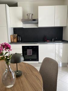 a kitchen with a table and a vase of flowers at seaview apartment - villa a’more in Milna